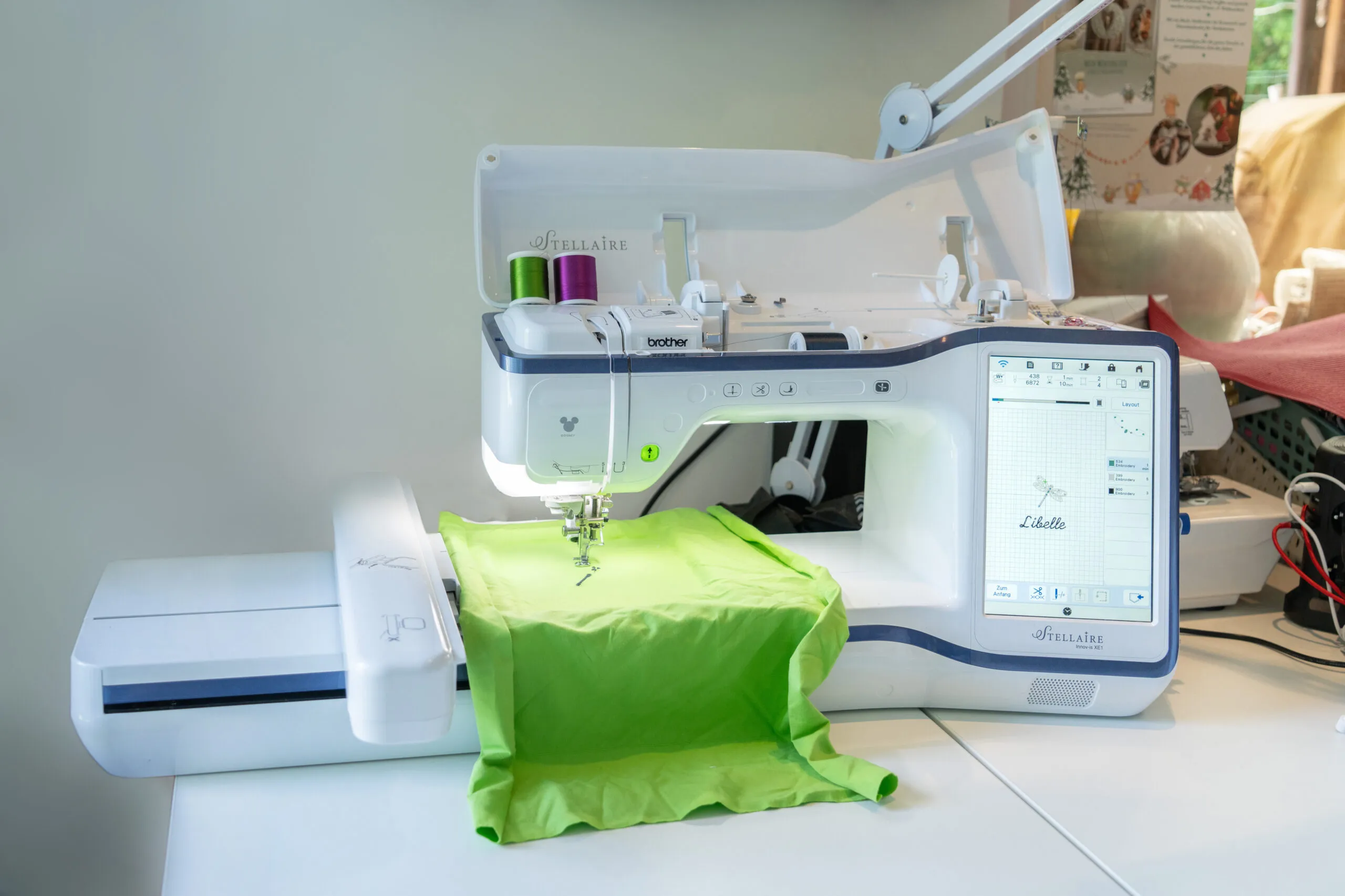 Stickmaschine mit grünem Stoff im Stickrahmen